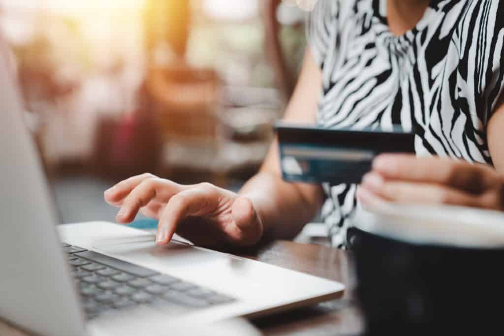 Woman making payments transaction through laptop computer with credit card